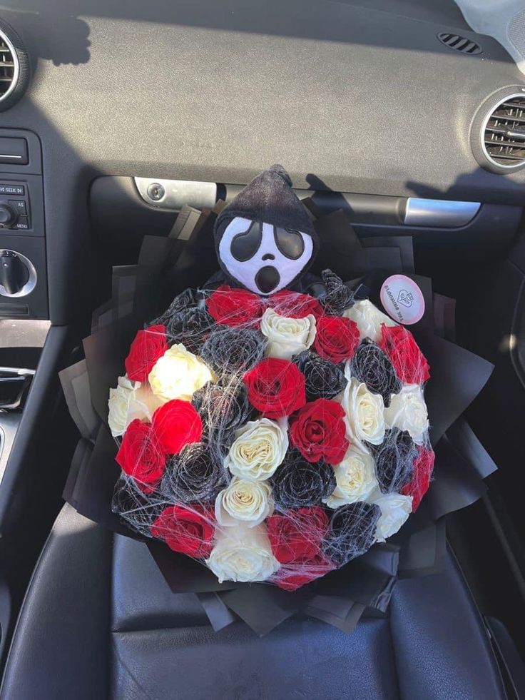Bouquet of red, white, and black roses with a ghostly figure in a car.